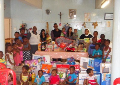 Coastal Accounting Staff and the wonderful Staff and Children from Assisisi posing with some of the donated goods
