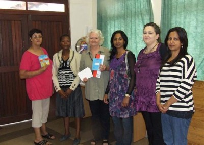 Nokthula, Fehmida, June & Charmaine handing over building vouchers, fans and stationery to Olive Smith, Principal of Merlewood Crechè 